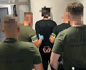 policjanci ze strażą graniczna pilnują zatrzymanego