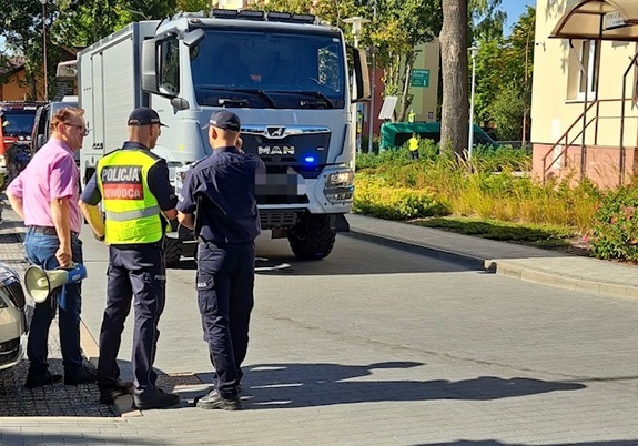 policjanci rozmawiają z zarządcą budynku