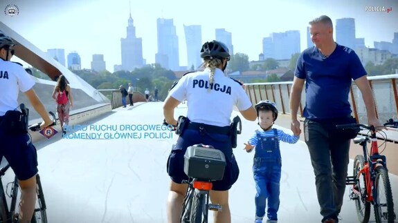 policjantka na rowerze mija dziecko i dorsłą osobę