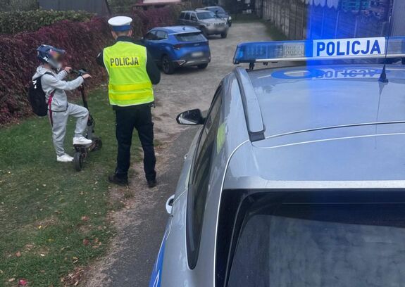 radiowóz policjant i dziecko na hulajnodze