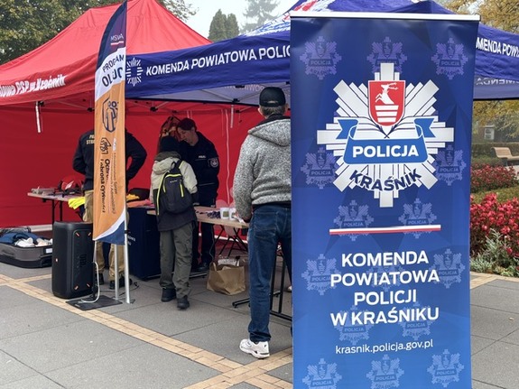 ludzie stojący obok policyjnego namiotu