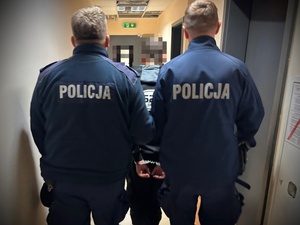 dwóch policjantów z zatrzymanym mężczyną