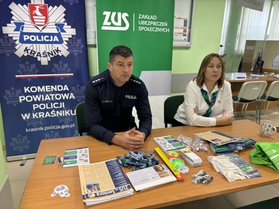 policjant oraz pracownica zus siedzą przy biurku