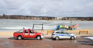 Widok na zalew, w tle radiowozy straży i policji